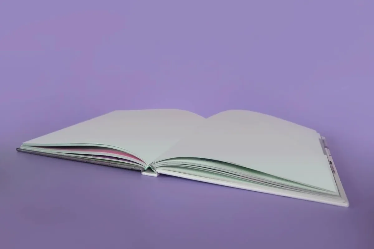 Caderno aberto com páginas numeradas sobre mesa de estudo
