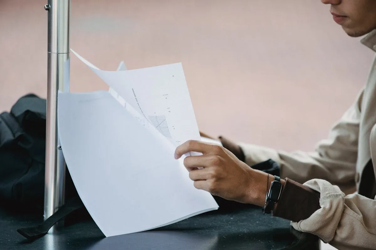 Pesquisadora organizando documentos e relatórios em mesa de trabalho acadêmico