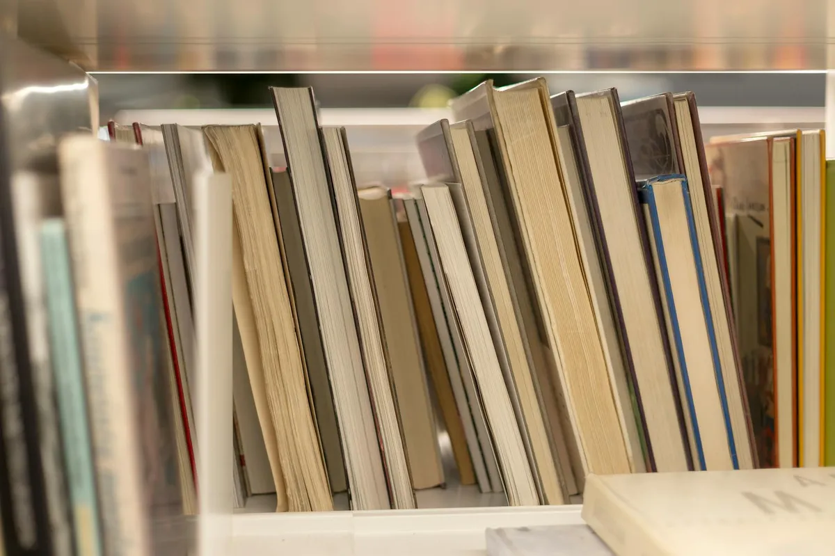 Pesquisadora lendo documentos acadêmicos em biblioteca