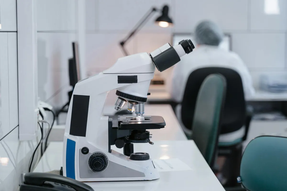 Pesquisadora em laboratório clínico analisando dados em computador