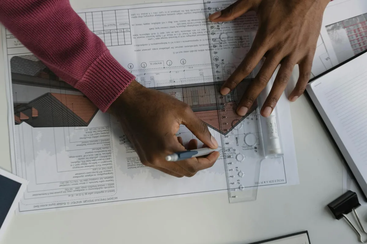 Engenheiro analisando planos e projetos técnicos em mesa de trabalho