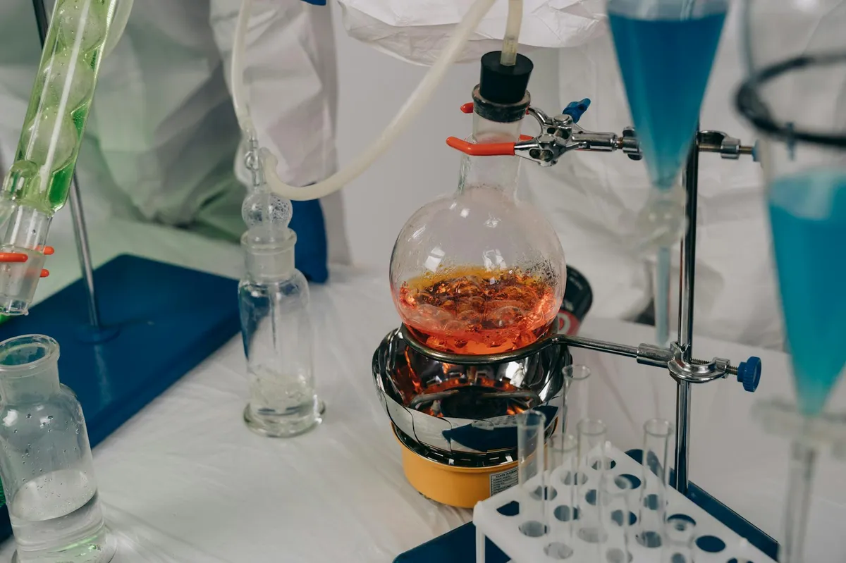 Laboratório científico com equipamentos e pesquisadora realizando experimento