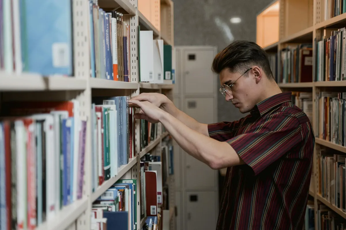 Pesquisadora explorando dados em biblioteca acadêmica com livros e laptop