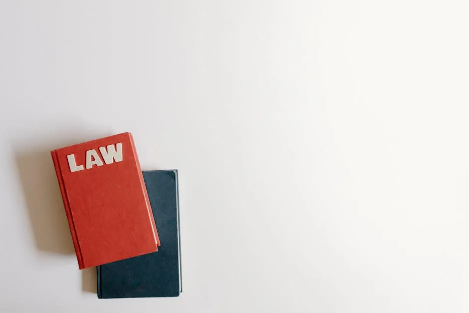 Mesa com livros jurídicos abertos, caneta e bloco de notas.