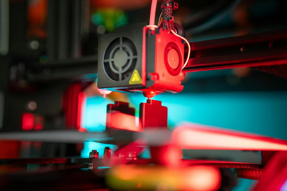 Pesquisadora em laboratório de tecnologia com equipamentos de prototipagem