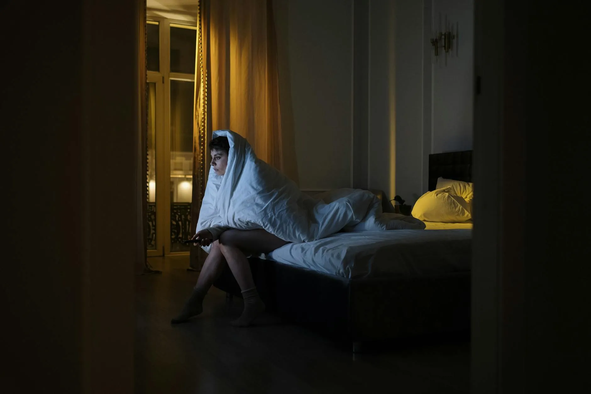 Pessoa acordada de madrugada olhando para tela de laptop em quarto escuro
