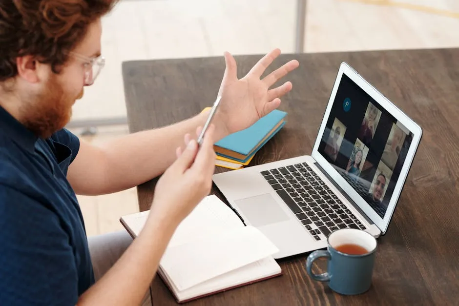 Pessoa em videoconferência acadêmica no computador em home office com cadernos na mesa