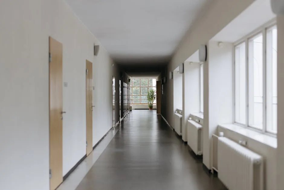 Corredor vazio de universidade com porta fechada, simbolizando apoio institucional inacessível