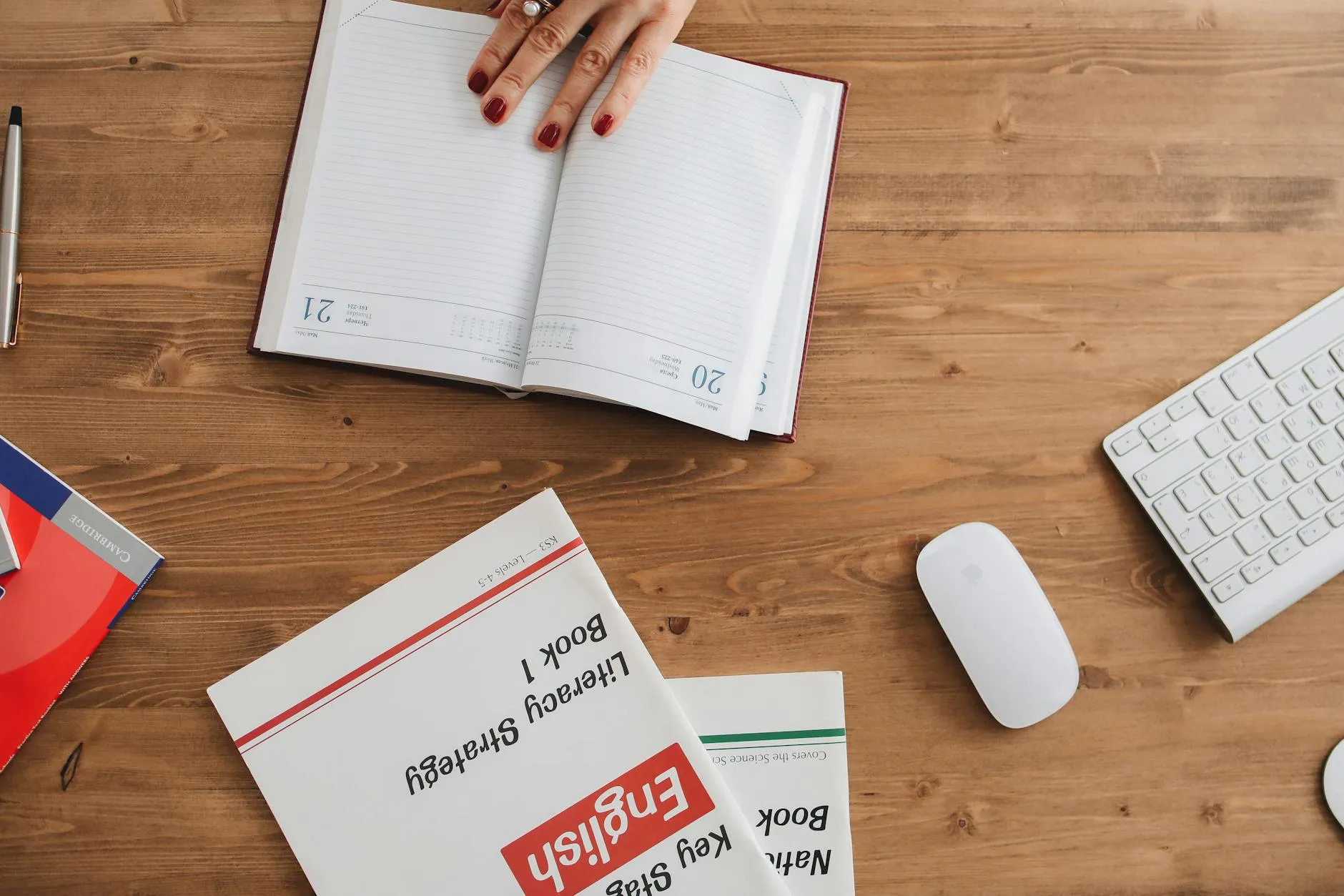 Caderno de estudos de inglês aberto com caneta e fone de ouvido