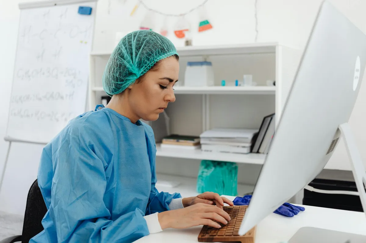 Pesquisadora usando computador para busca bibliográfica em base de dados científica
