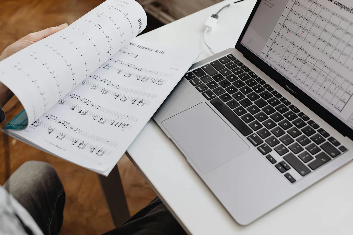 Caderno com anotações conceituais e livros de teoria abertos em mesa de estudo
