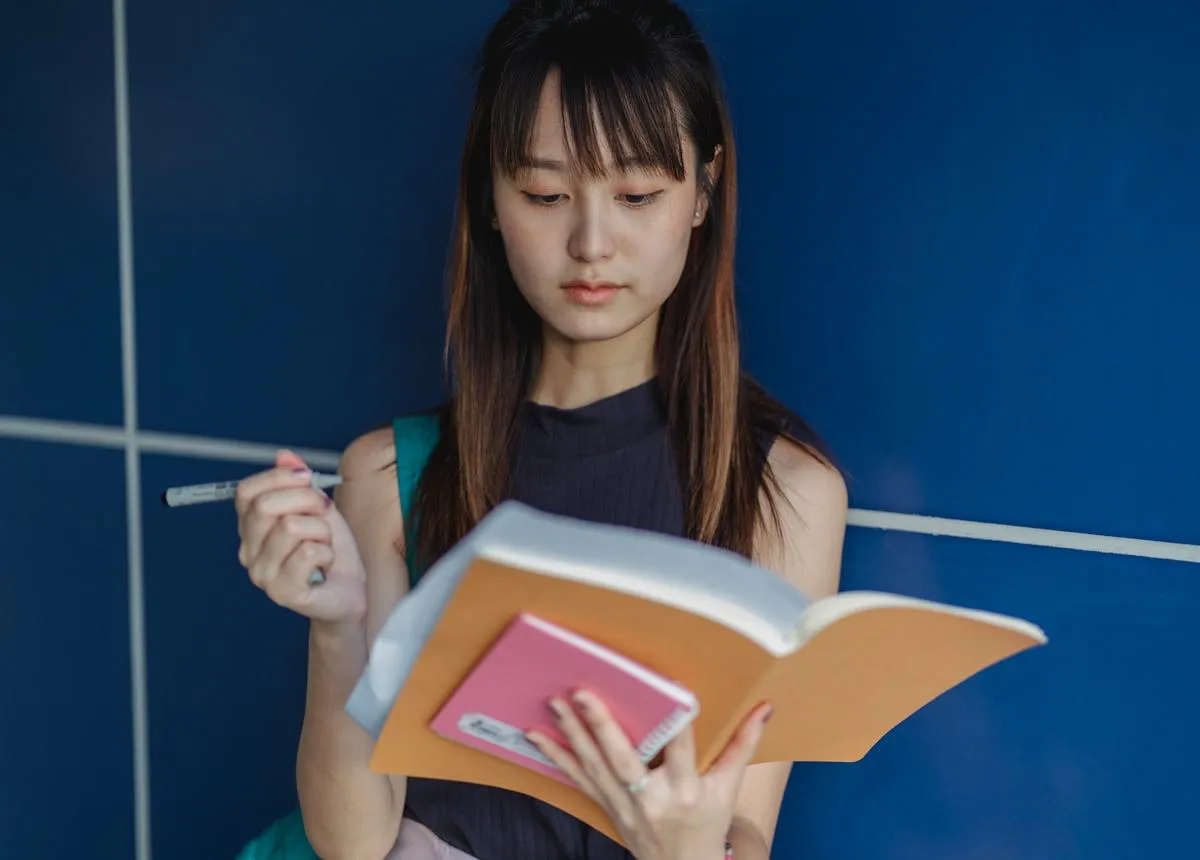 Estudante analisando a estrutura de texto acadêmico em notebook com anotações