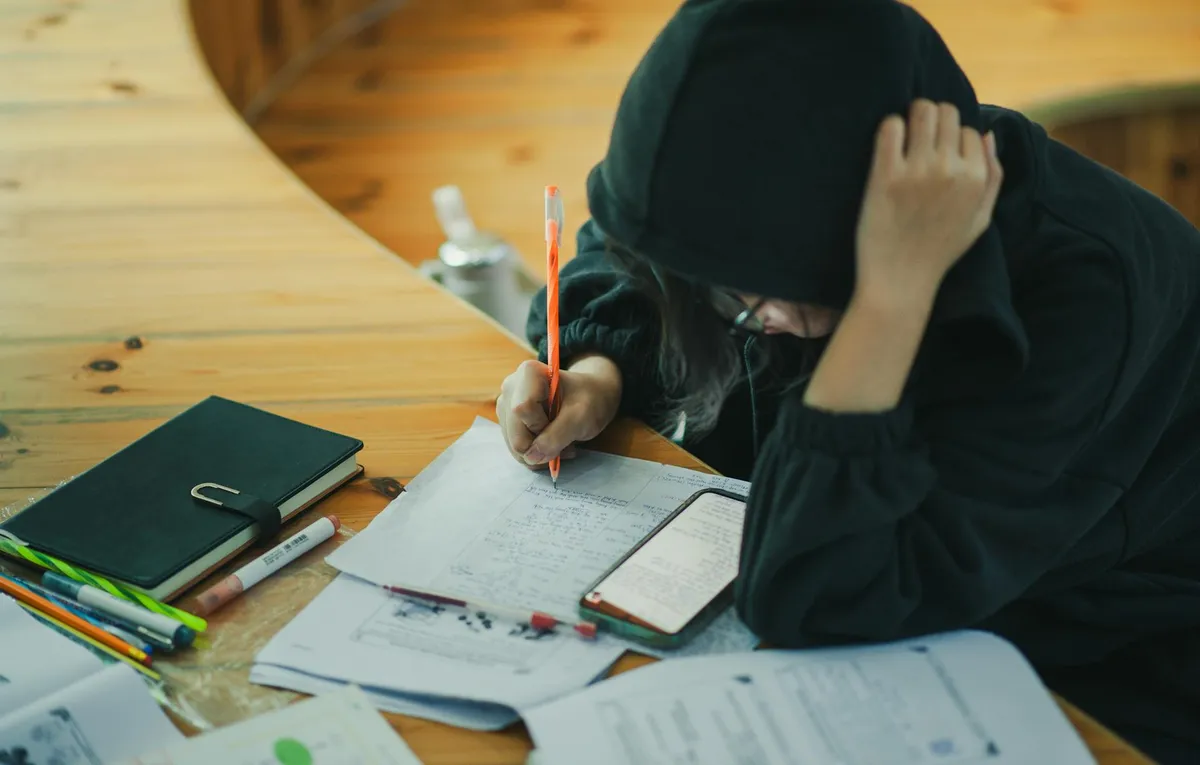 Caderno com anotações acadêmicas sobre uma mesa de estudos