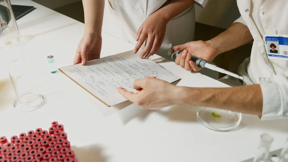 Documentos científicos empilhados sobre mesa representando fragmentação de pesquisa
