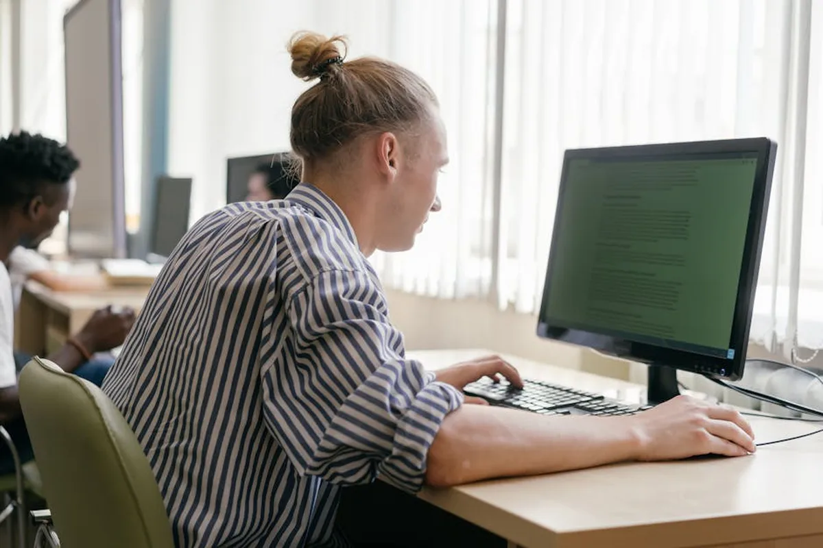 Pesquisadora em frente ao computador consultando banco de dados acadêmico