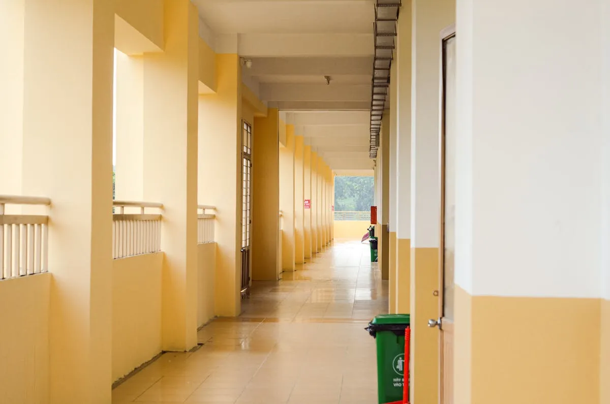 Corredor de universidade vazio com portas de salas fechadas