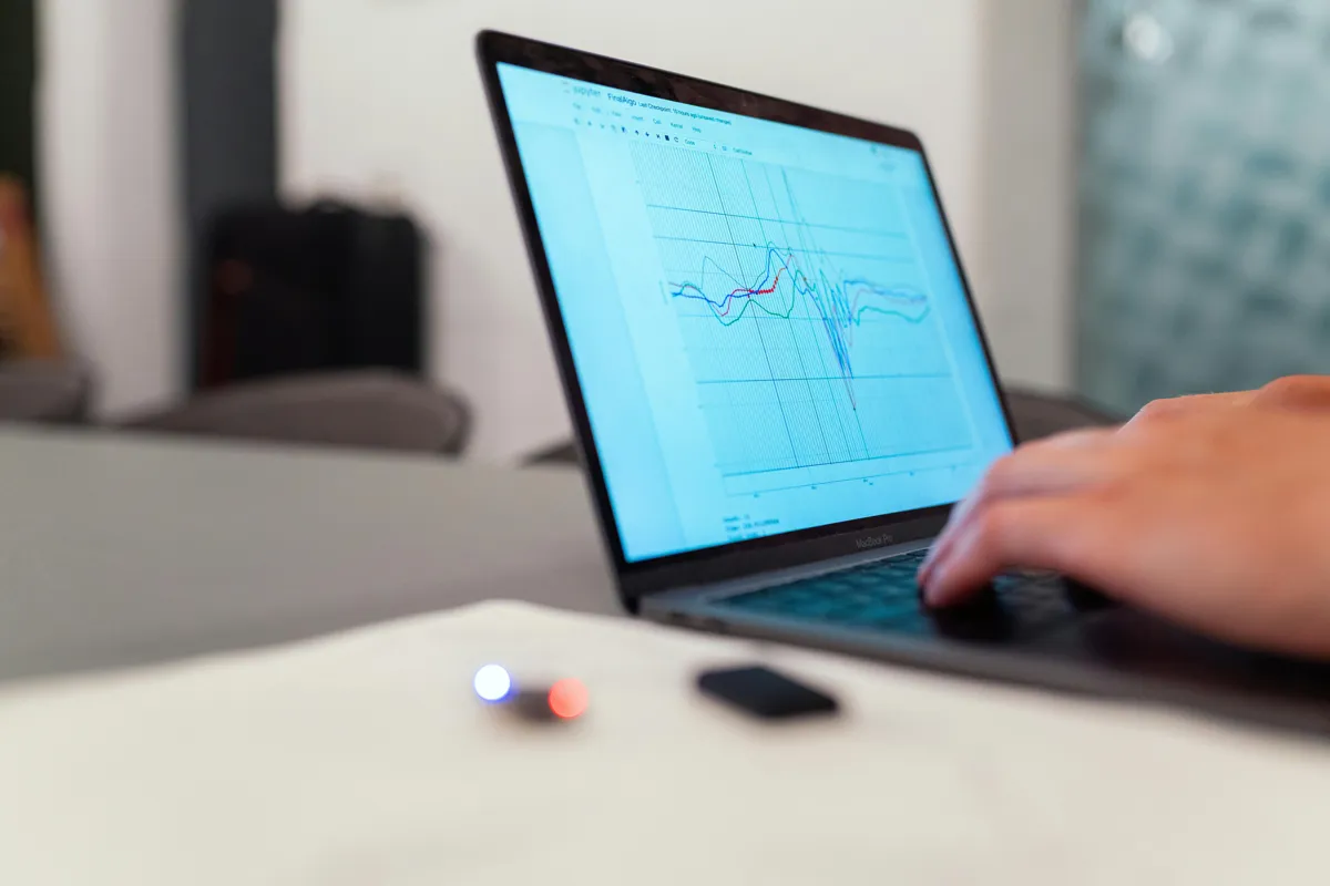Pesquisadora analisando tabela de dados estatísticos em computador.