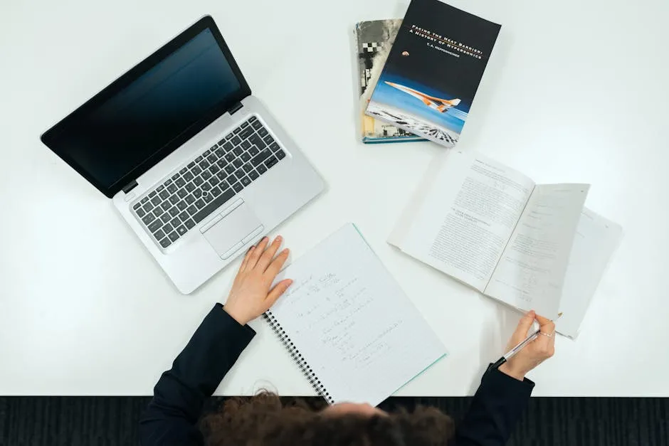 Estudante de engenharia analisando projeto com prancheta e calculadora sobre a mesa